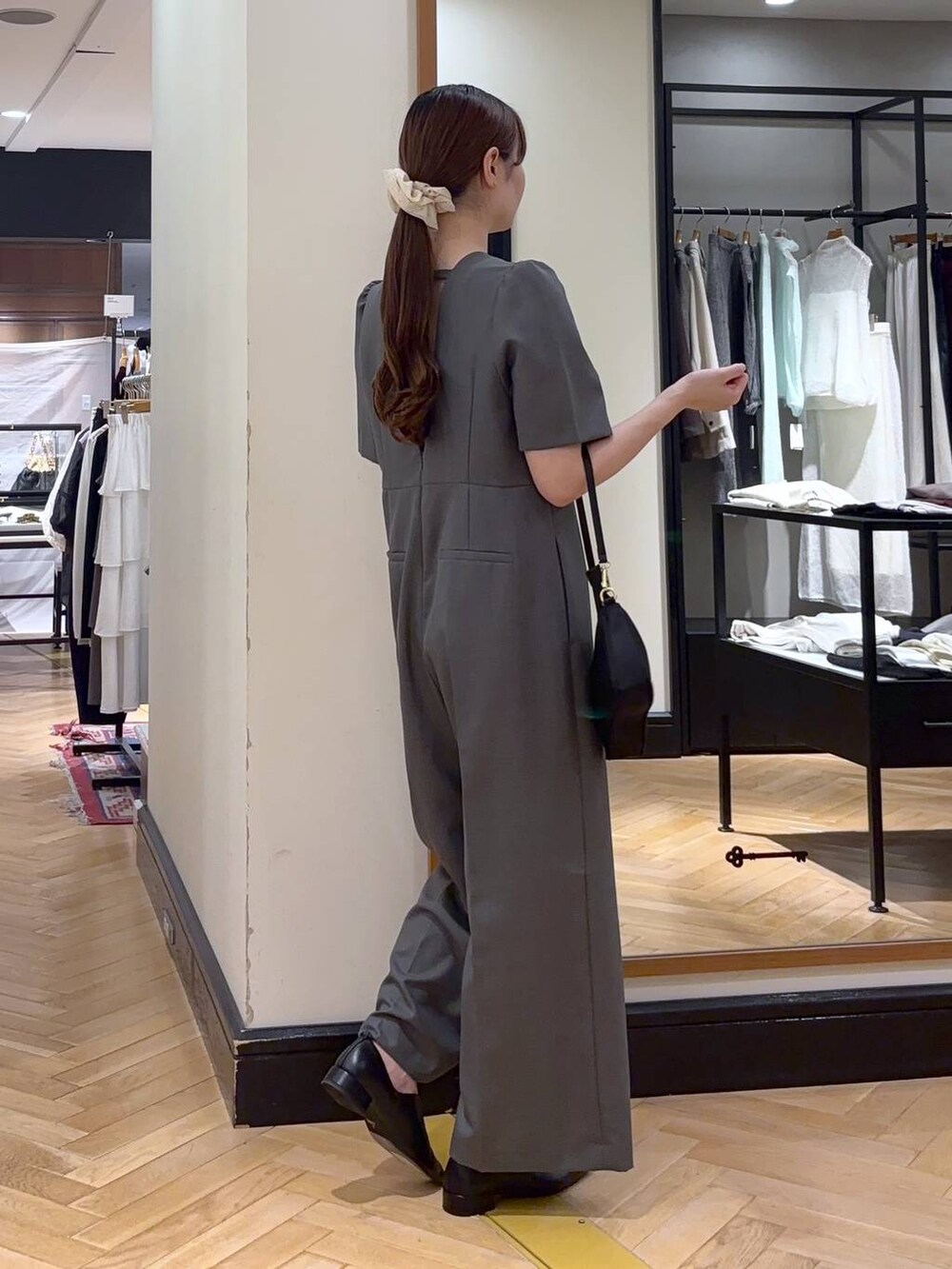 ブラック系のパンプス、ブラック系のショルダーバッグ、グレー系のつなぎ/オールインワンを着用したレディースの秋コーディネートの4枚目の写真