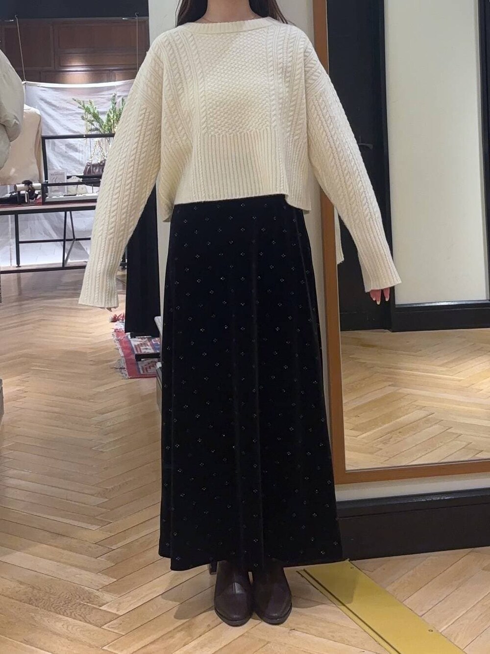 ホワイト系のピーコート、ブラウン系のブーツ、ホワイト系のニット/セーターを着用したレディースの冬コーディネートの4枚目の写真