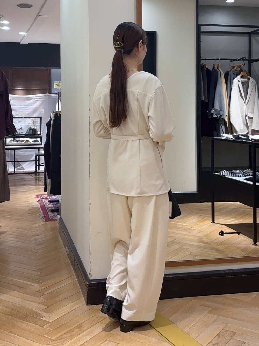 ホワイト系のスラックス、ブラック系のローファー、ブラック系のショルダーバッグを着用したレディースの秋コーディネートの4枚目の写真