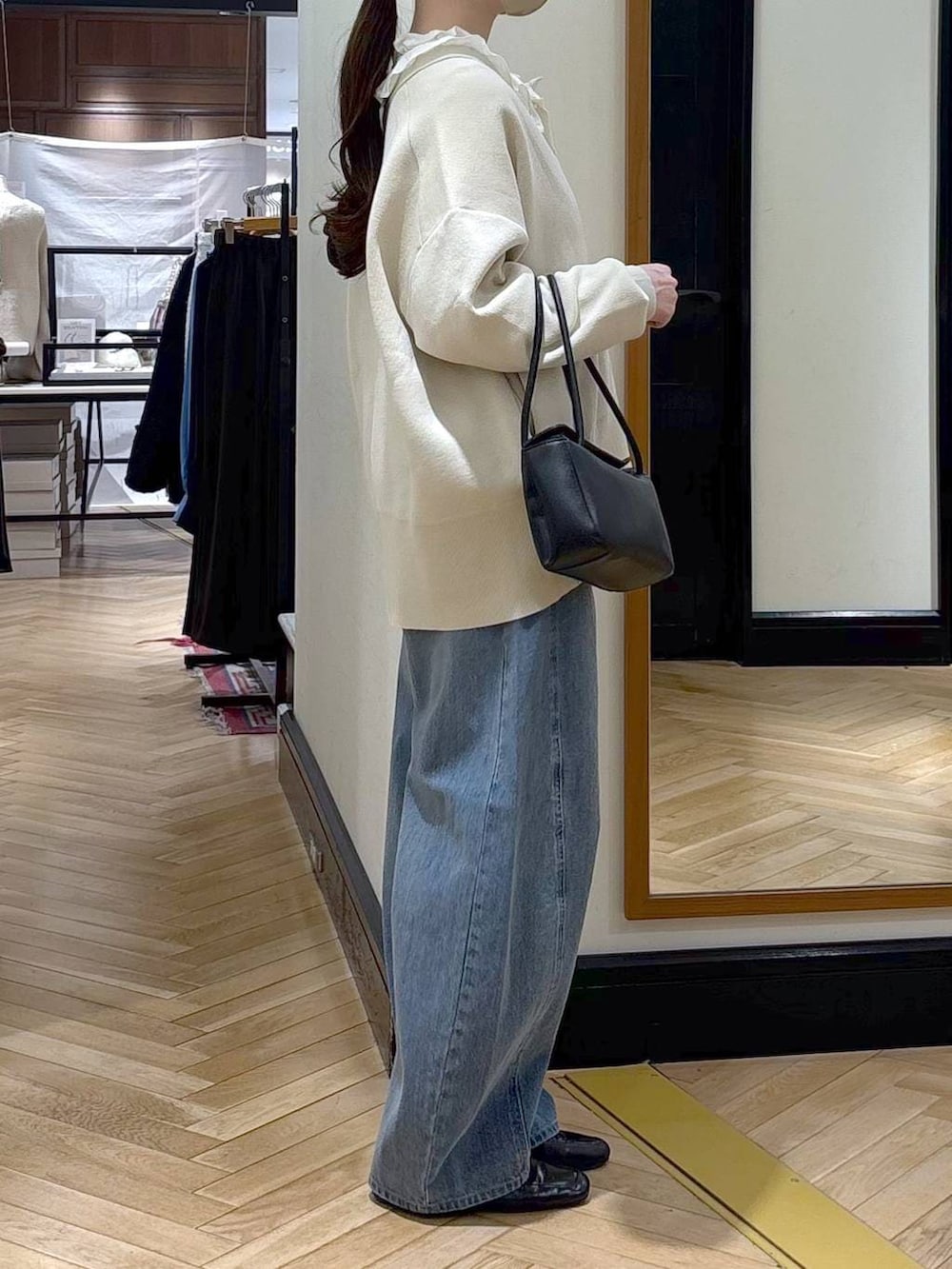 ブルー系のデニムパンツ、ブラック系のローファー、ホワイト系のカーディガン/ボレロを着用したレディースの冬コーディネートの2枚目の写真