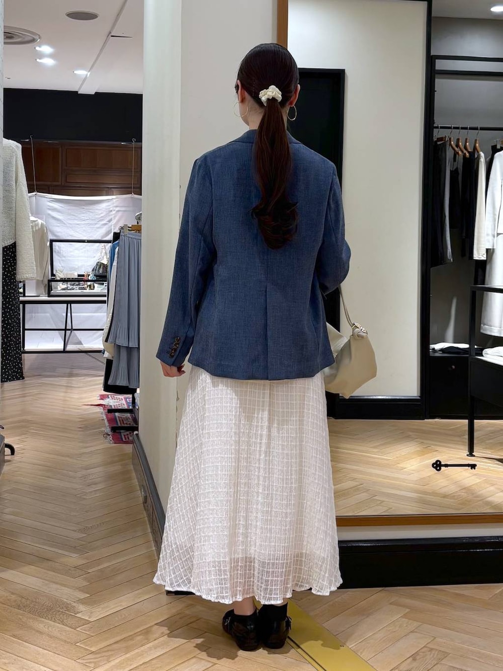 ベージュ系のショルダーバッグ、ブルー系のノーカラージャケット、ブルー系のTシャツ/カットソーを着用したレディースの春コーディネートの4枚目の写真