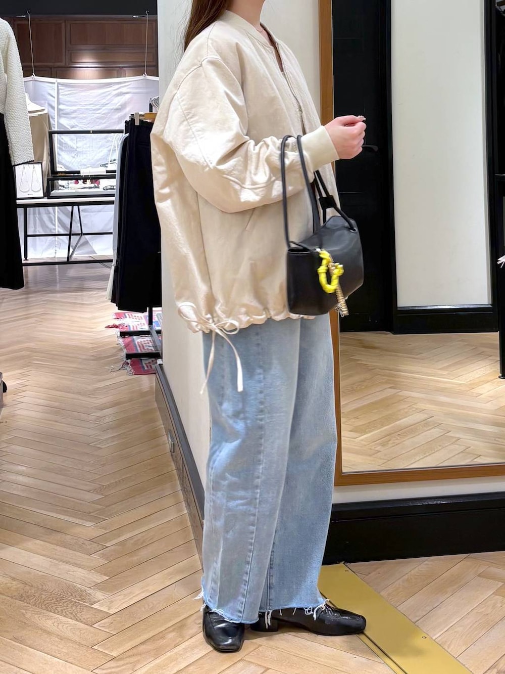 ブラック系のローファー、ベージュ系のMA-1、ブルー系のデニムパンツを着用したレディースの冬コーディネートの2枚目の写真