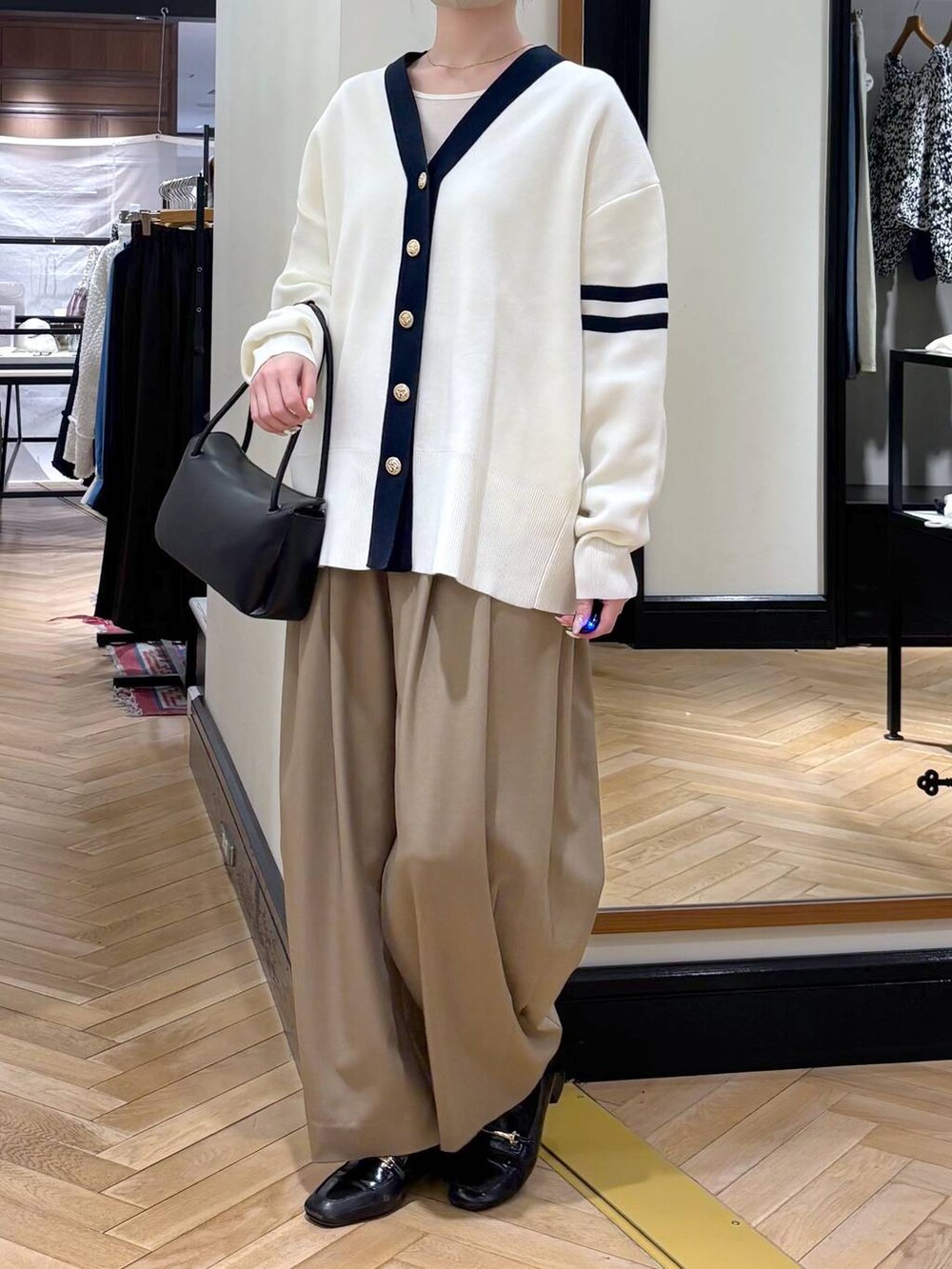 ベージュ系のスラックス、ブラック系のローファー、ブラック系のカーディガン/ボレロを着用したレディースの冬コーディネートの3枚目の写真