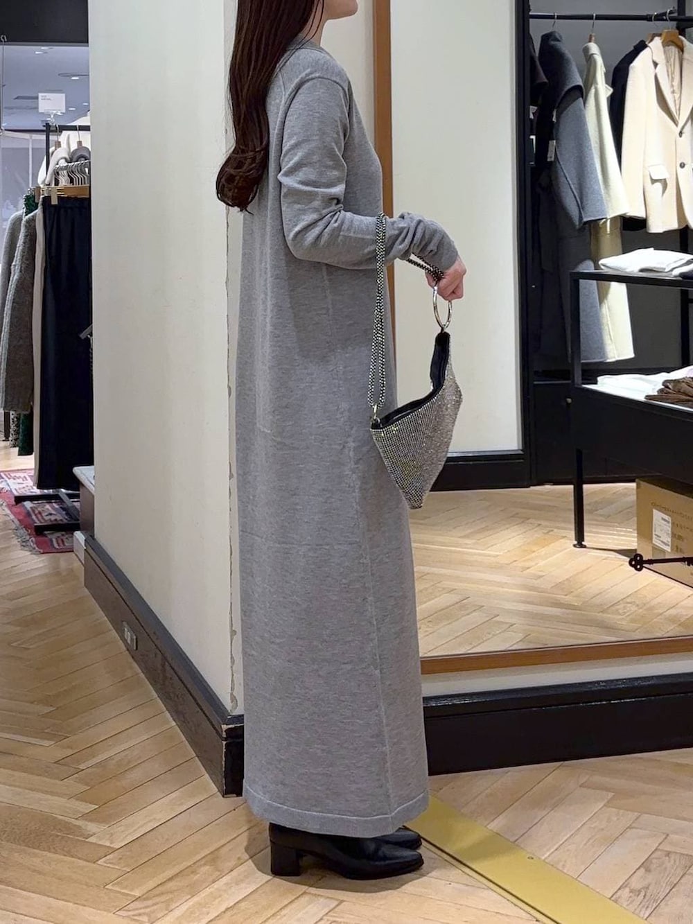 ブラック系のブーツ、グレー系のワンピース、シルバー系のショルダーバッグを着用したレディースの冬コーディネートの2枚目の写真