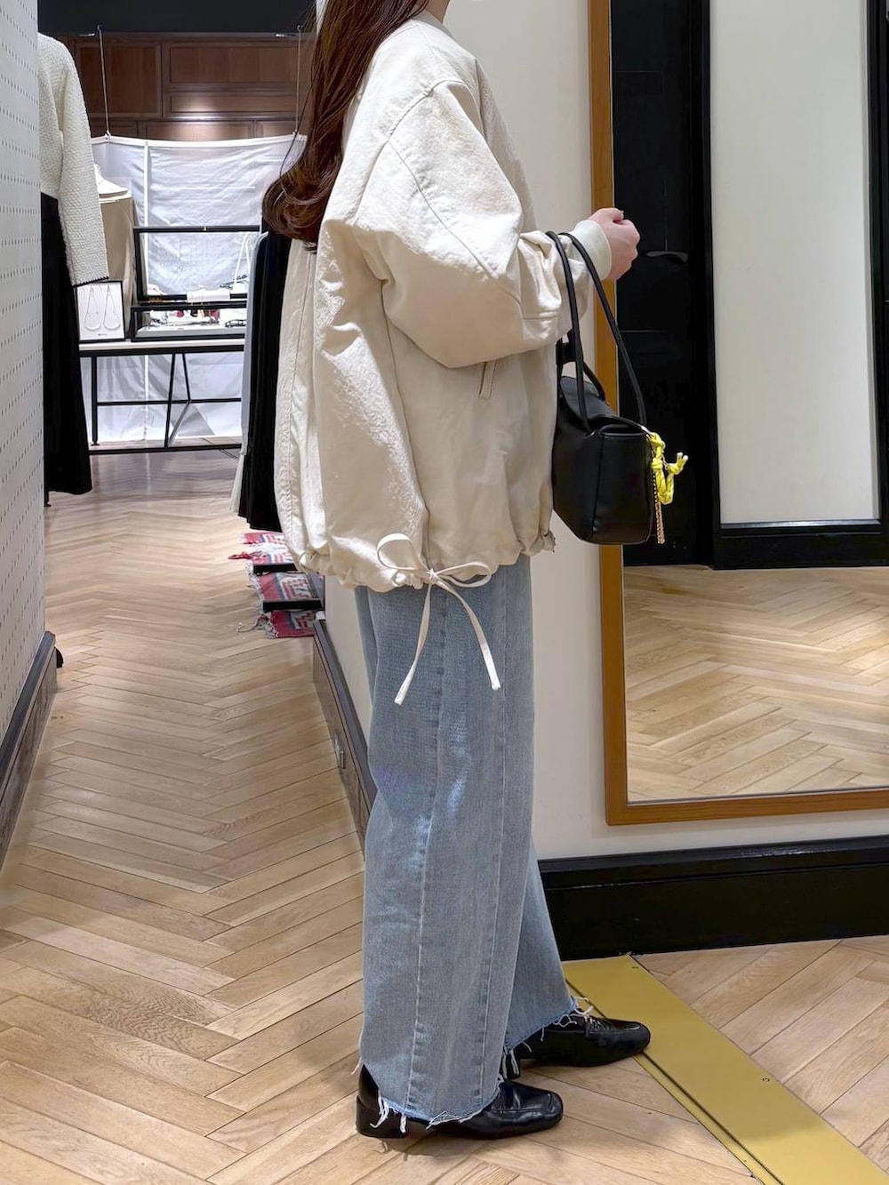 ブラック系のローファー、ベージュ系のMA-1、ブルー系のデニムパンツを着用したレディースの冬コーディネートの3枚目の写真