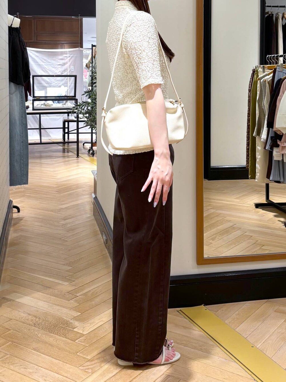 ホワイト系のショルダーバッグ、ホワイト系のTシャツ/カットソー、ホワイト系のサンダルを着用したレディースの夏コーディネートの2枚目の写真