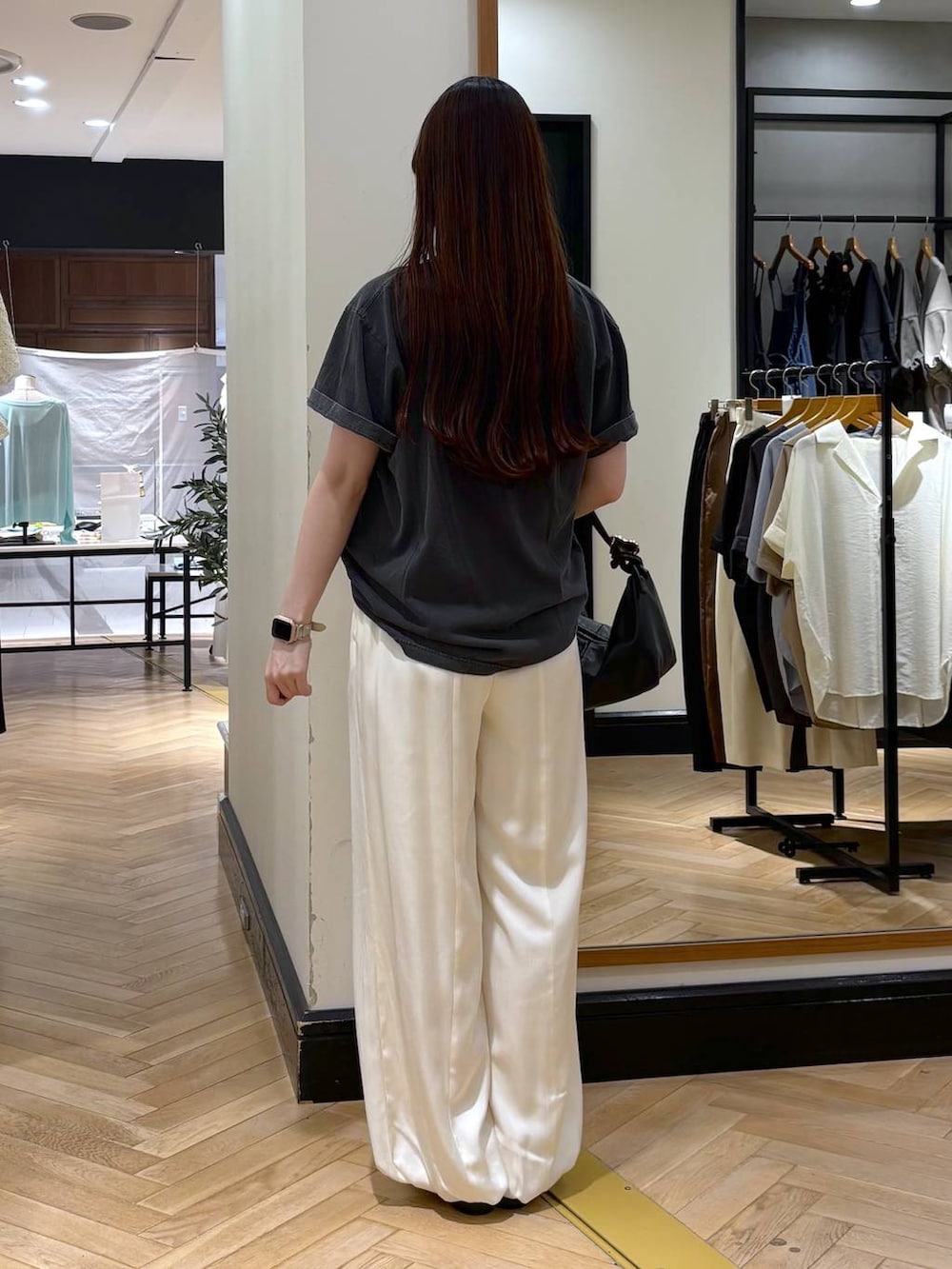 ブラック系のショルダーバッグ、グレー系のTシャツ/カットソー、ブラック系のパンプスを着用したレディースの夏コーディネートの4枚目の写真
