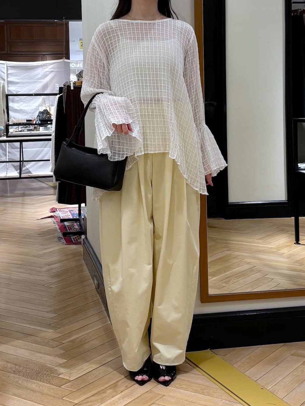 ブラック系のショルダーバッグ、ブラック系のサンダルを着用したレディースの春コーディネートの4枚目の写真