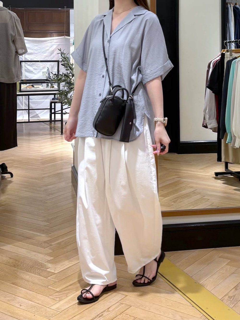 ブルー系のシャツ/ブラウス、ホワイト系のその他パンツ、ブラック系のショルダーバッグを着用したレディースの春コーディネートの3枚目の写真