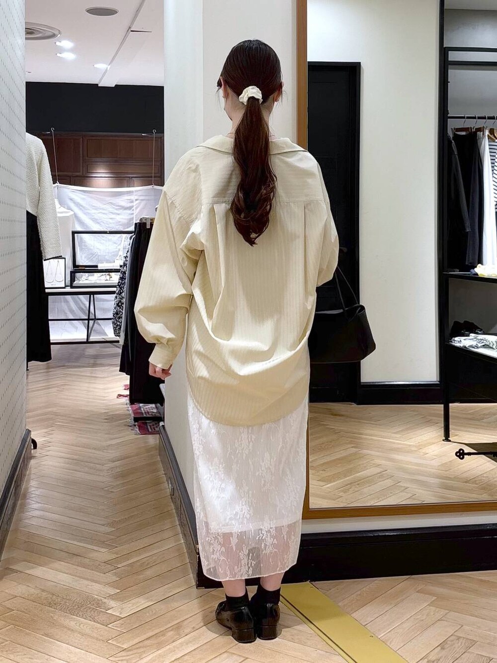 ブラック系のローファー、ホワイト系のスカート、イエロー系のシャツ/ブラウスを着用したレディースの冬コーディネートの6枚目の写真