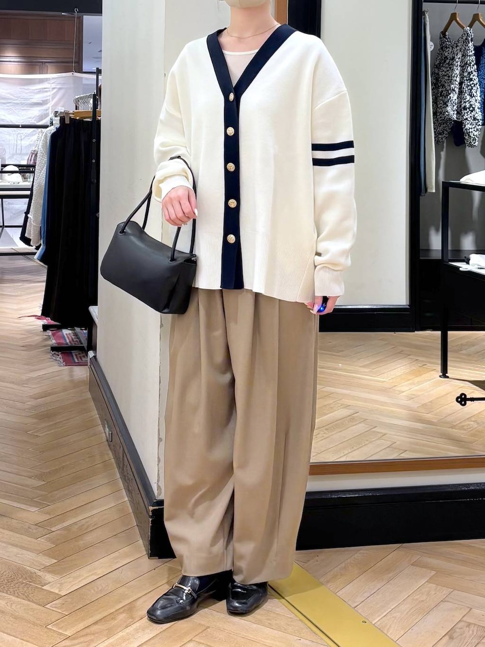 ベージュ系のスラックス、ブラック系のローファー、ブラック系のカーディガン/ボレロを着用したレディースの冬コーディネートの2枚目の写真