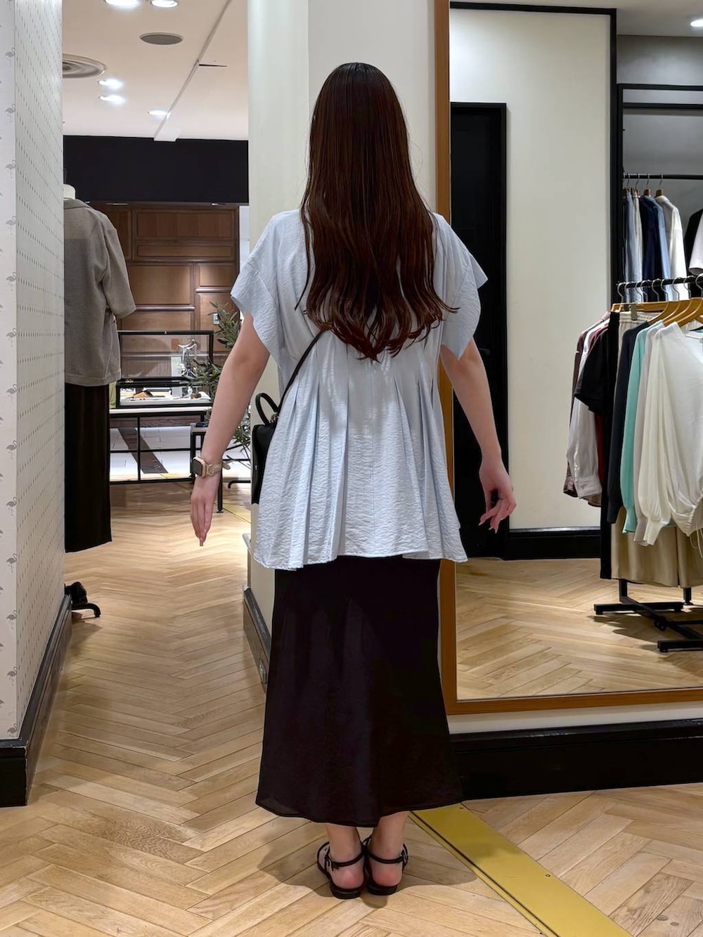 ブルー系のシャツ/ブラウス、ブラック系のスカート、ブラック系のショルダーバッグを着用したレディースの春コーディネートの3枚目の写真