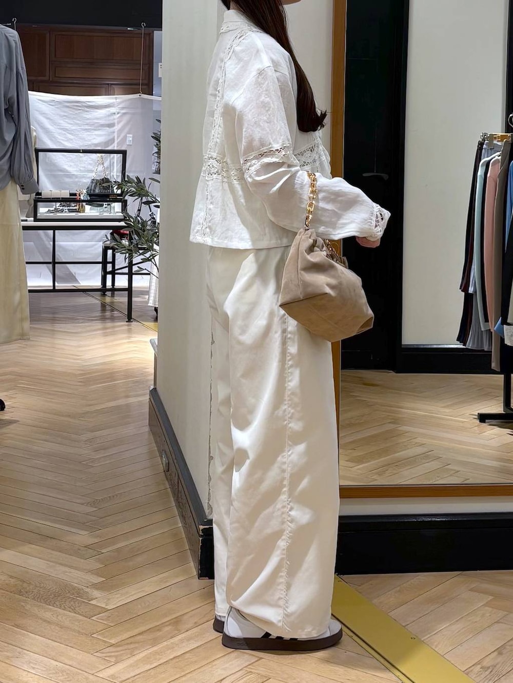 ベージュ系のショルダーバッグ、ホワイト系のスラックス、ホワイト系のシャツ/ブラウスを着用したレディースの春コーディネートの2枚目の写真