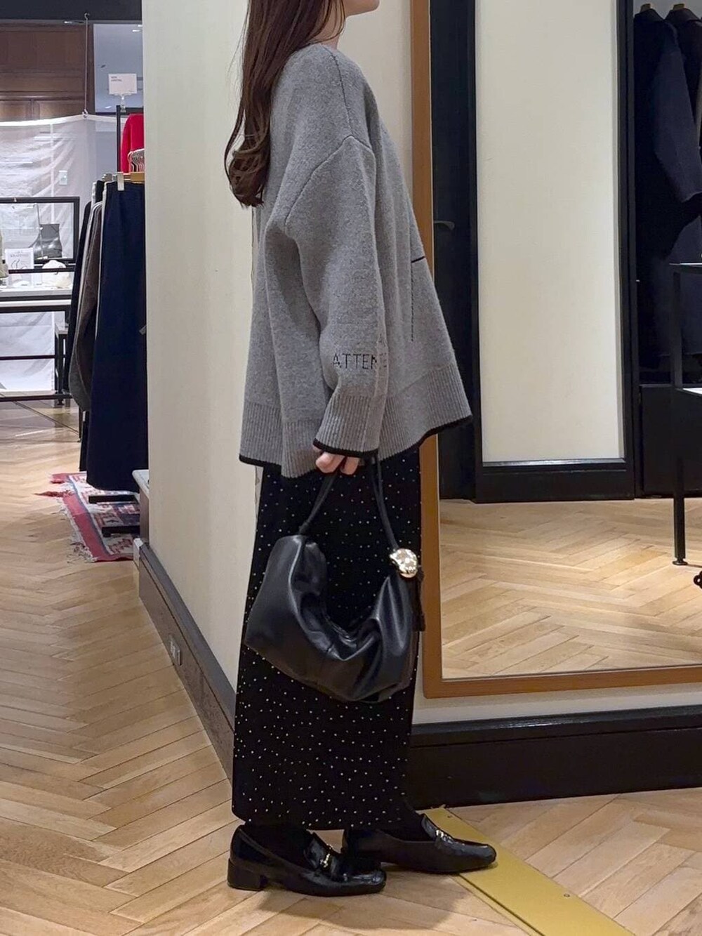 ブラック系のローファー、その他のスカート、ブラック系のショルダーバッグを着用したレディースの秋コーディネートの2枚目の写真