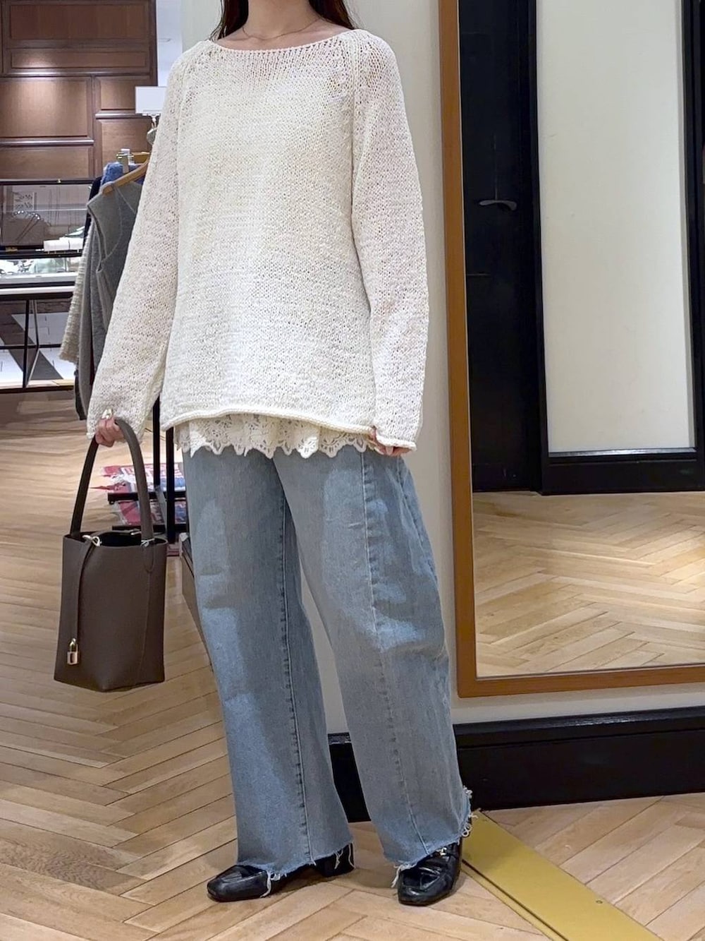 ブルー系のデニムパンツ、ブラック系のローファー、ホワイト系のキャミソールを着用したレディースの冬コーディネートの2枚目の写真