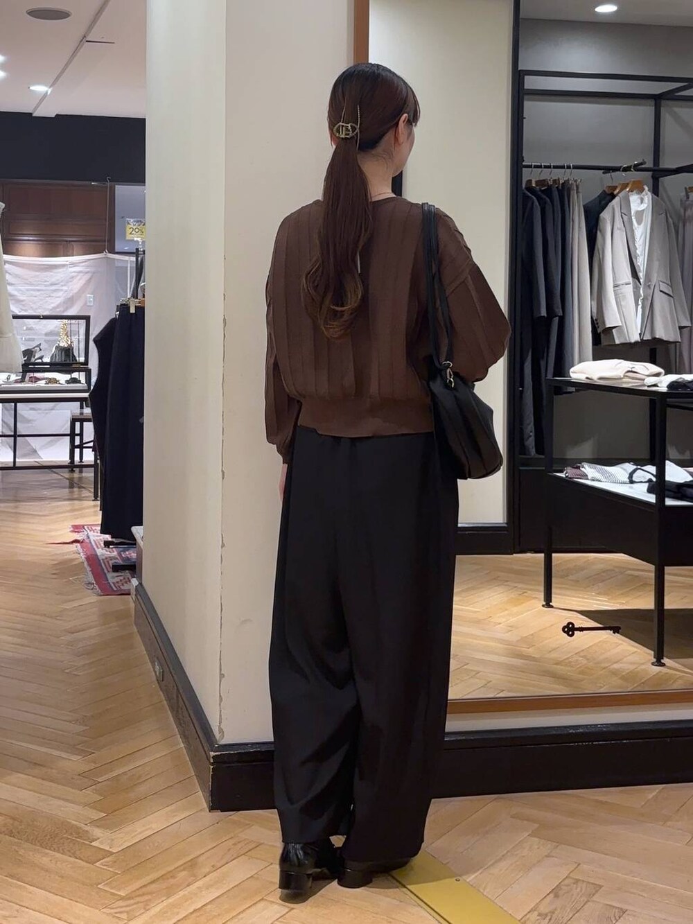 ブラック系のハンドバッグ、ブラウン系のカーディガン/ボレロ、ブラック系のローファーを着用したレディースの秋コーディネートの5枚目の写真