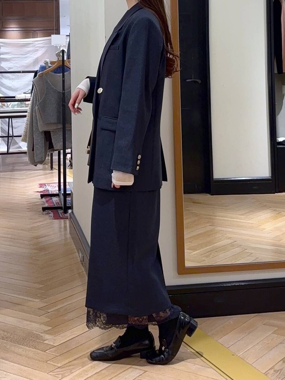 ブラック系のローファー、ブルー系のスカート、ブルー系のテーラードジャケットを着用したレディースの冬コーディネートの3枚目の写真