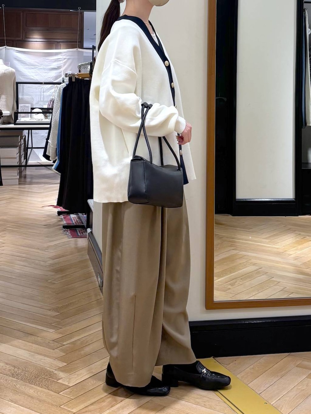 ベージュ系のスラックス、ブラック系のローファー、ブラック系のカーディガン/ボレロを着用したレディースの冬コーディネートの5枚目の写真