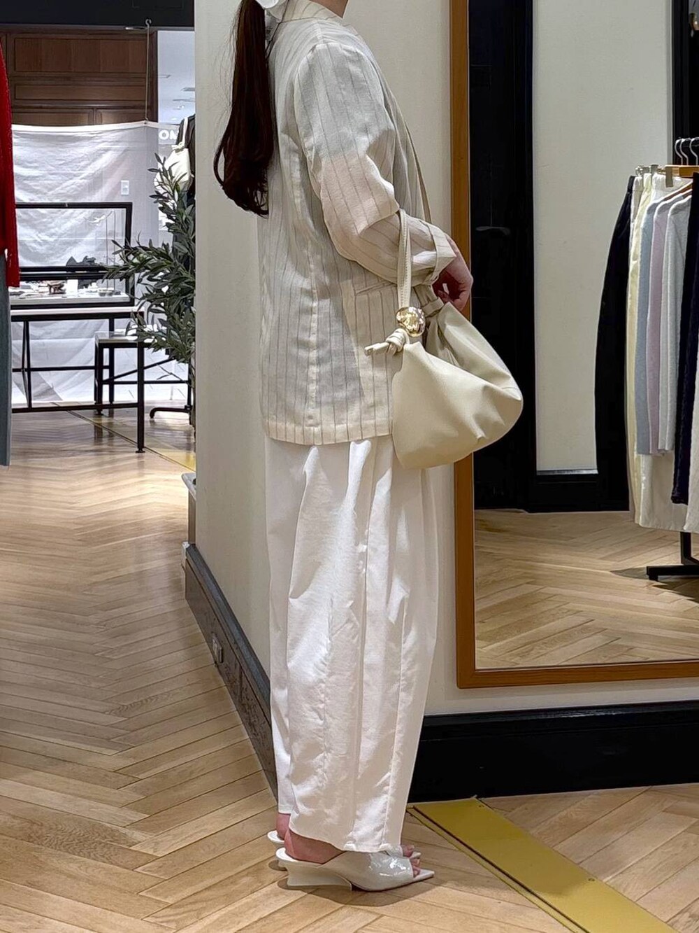 ベージュ系のテーラードジャケット、ホワイト系のショルダーバッグ、グレー系のTシャツ/カットソーを着用したレディースの春コーディネートの2枚目の写真