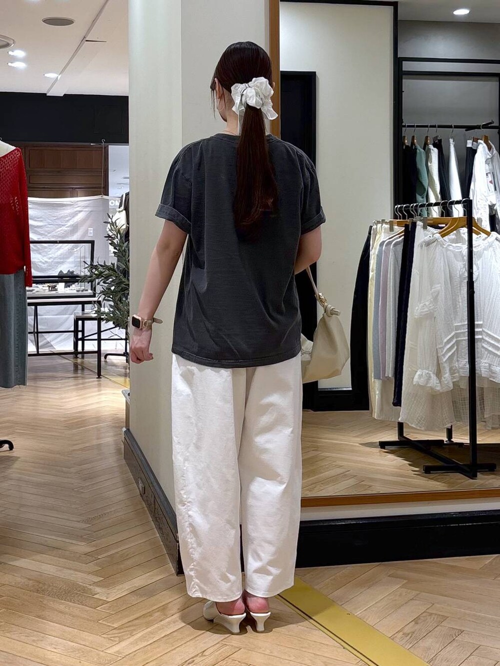 ホワイト系のショルダーバッグ、グレー系のTシャツ/カットソー、ホワイト系のサンダルを着用したレディースの春コーディネートの4枚目の写真