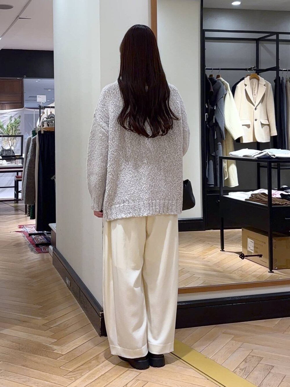 ホワイト系のスラックス、ブラック系のローファー、グレー系のニット/セーターを着用したレディースの冬コーディネートの4枚目の写真