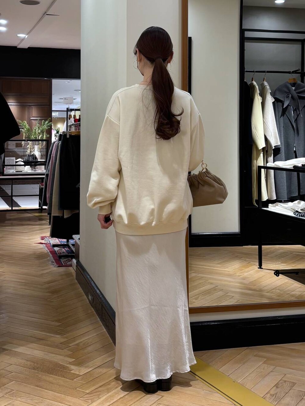 ブラック系のローファー、ホワイト系のスカート、ベージュ系のショルダーバッグを着用したレディースの冬コーディネートの5枚目の写真