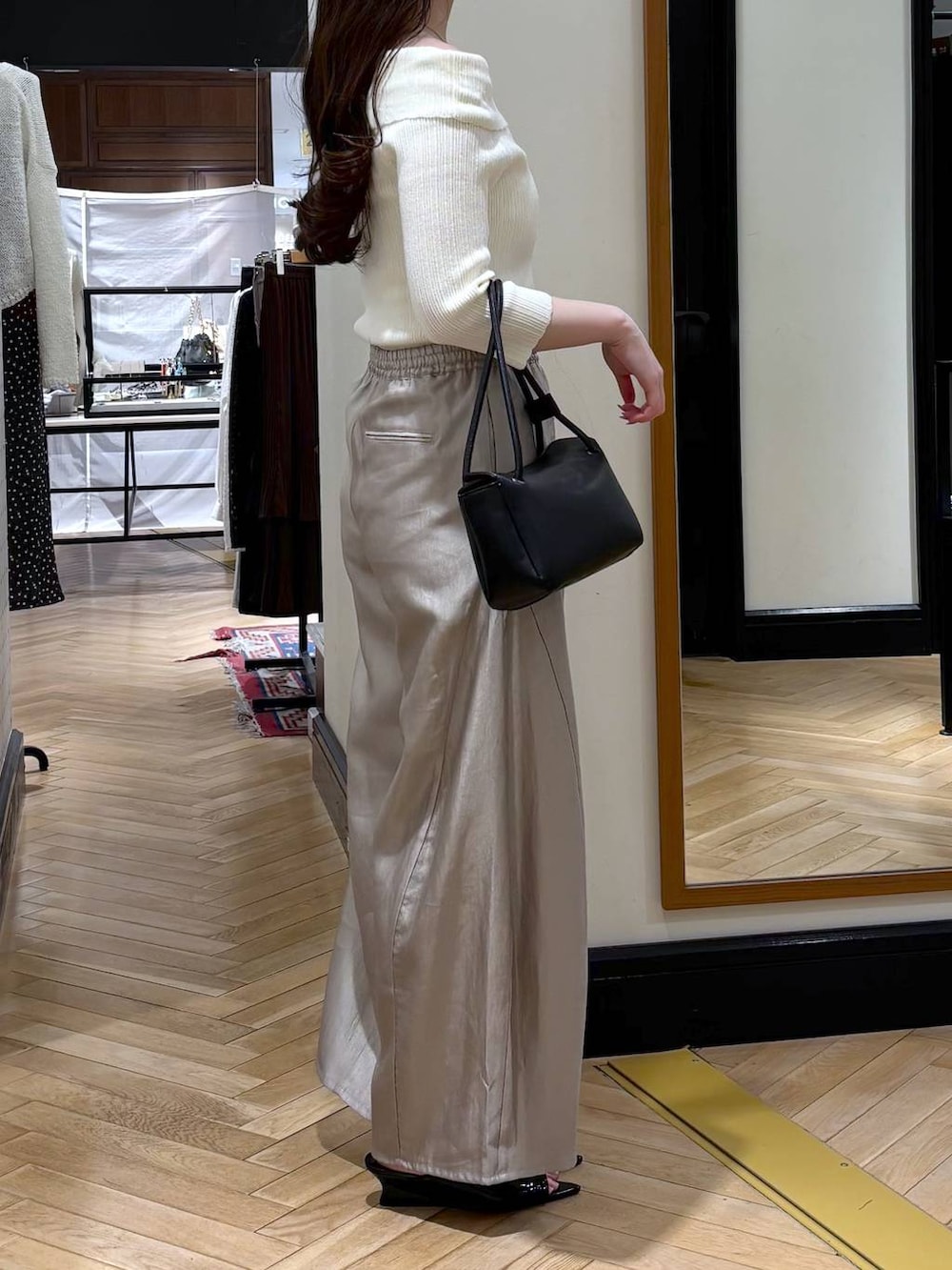 グレー系のその他パンツ、ブラック系のショルダーバッグ、ホワイト系のニット/セーターを着用したレディースの春コーディネートの2枚目の写真