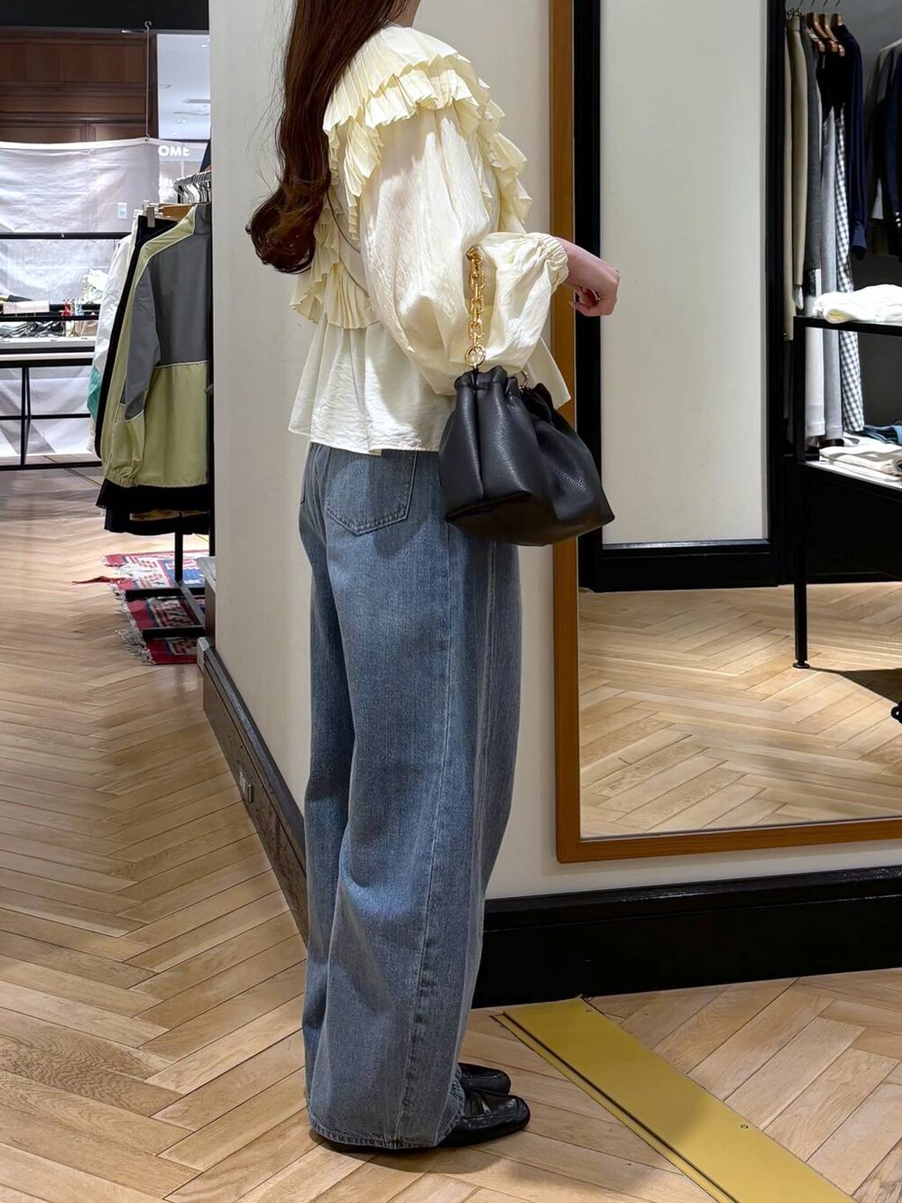 ブルー系のデニムパンツ、ブラック系のローファー、ブラック系のショルダーバッグを着用したレディースの春コーディネートの2枚目の写真