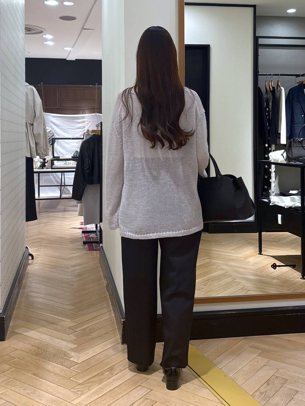 ブラック系のローファー、ブラック系のショルダーバッグ、ブラック系のチノパンツを着用したレディースの春コーディネートの5枚目の写真