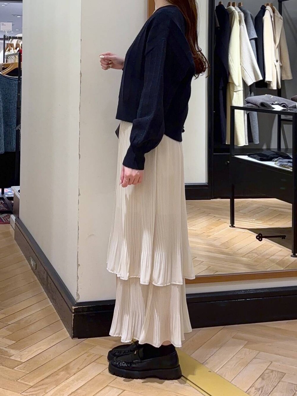 ホワイト系のスカート、ブラック系のショルダーバッグ、ブルー系のカーディガン/ボレロを着用したレディースの冬コーディネートの3枚目の写真