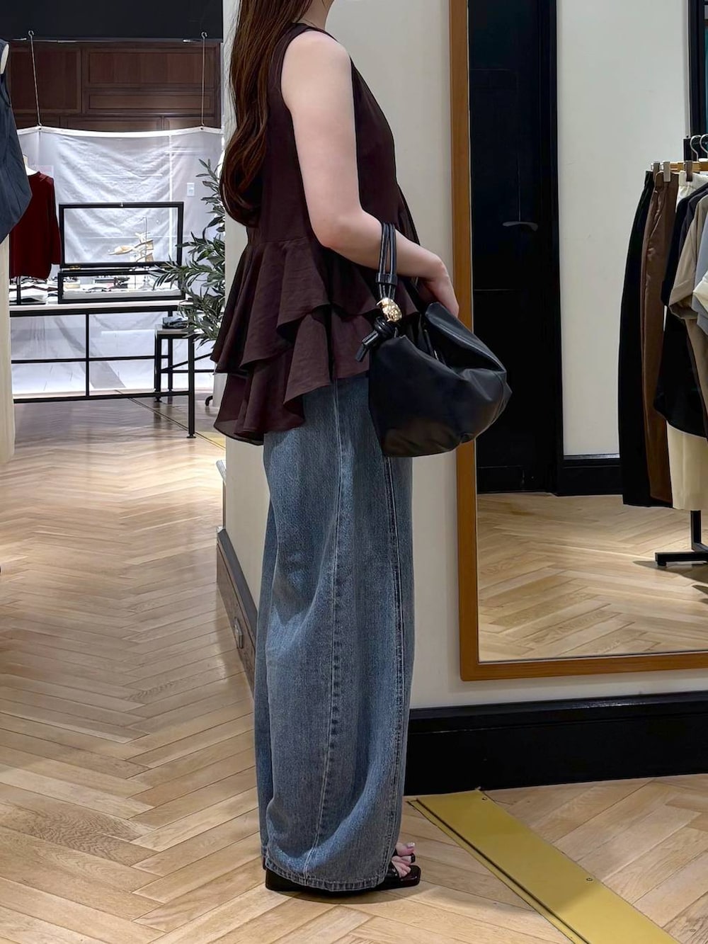 ブルー系のデニムパンツ、ブラック系のショルダーバッグ、ブラック系のパンプスを着用したレディースの夏コーディネートの2枚目の写真