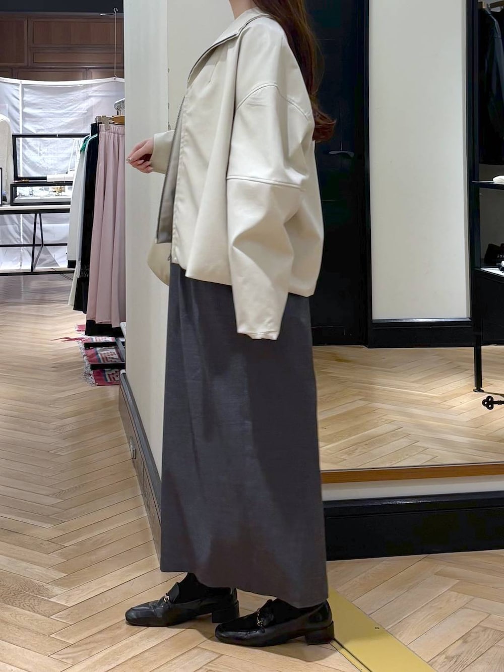 ブラック系のローファー、ホワイト系のブルゾン、グレー系のワンピースを着用したレディースの春コーディネートの3枚目の写真