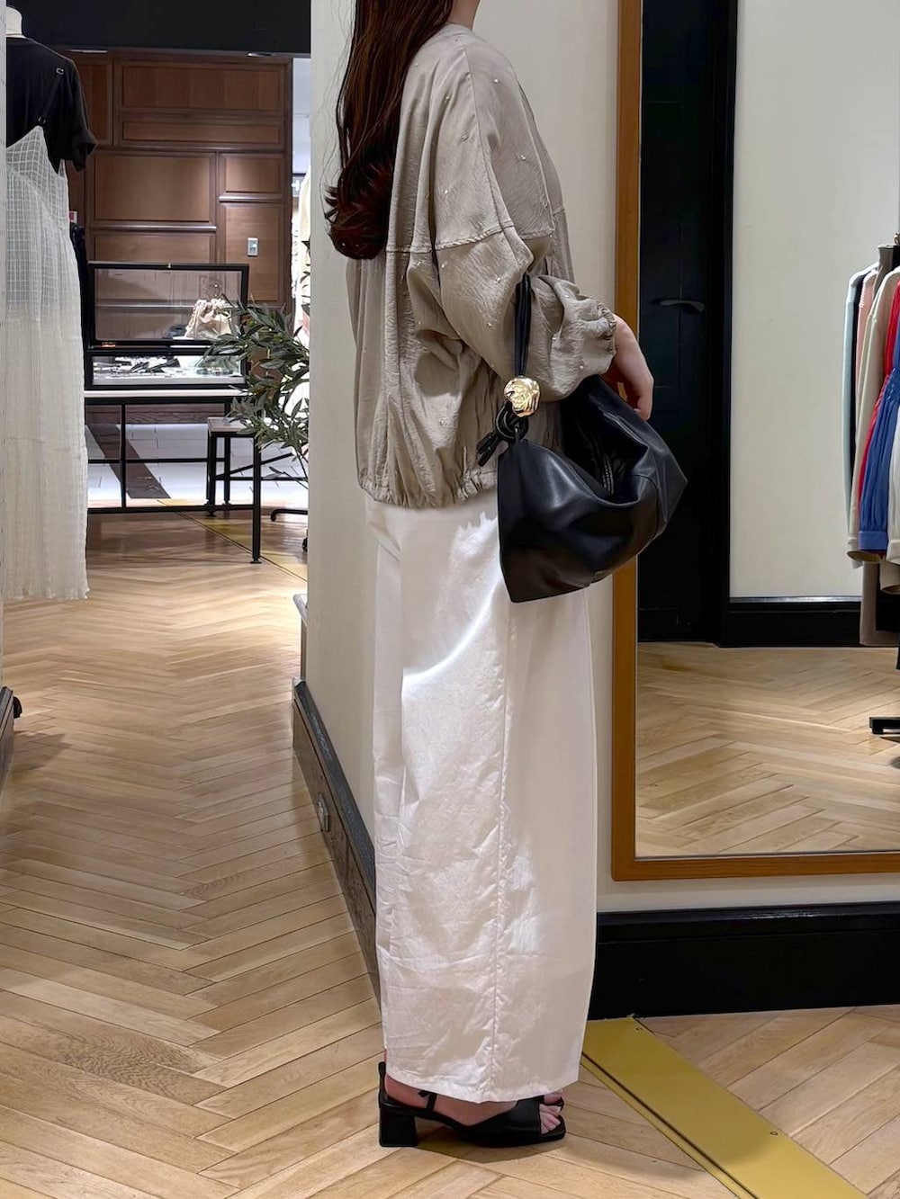 ブラック系のショルダーバッグ、ホワイト系のタンクトップ、ブラック系のサンダルを着用したレディースの春コーディネートの2枚目の写真