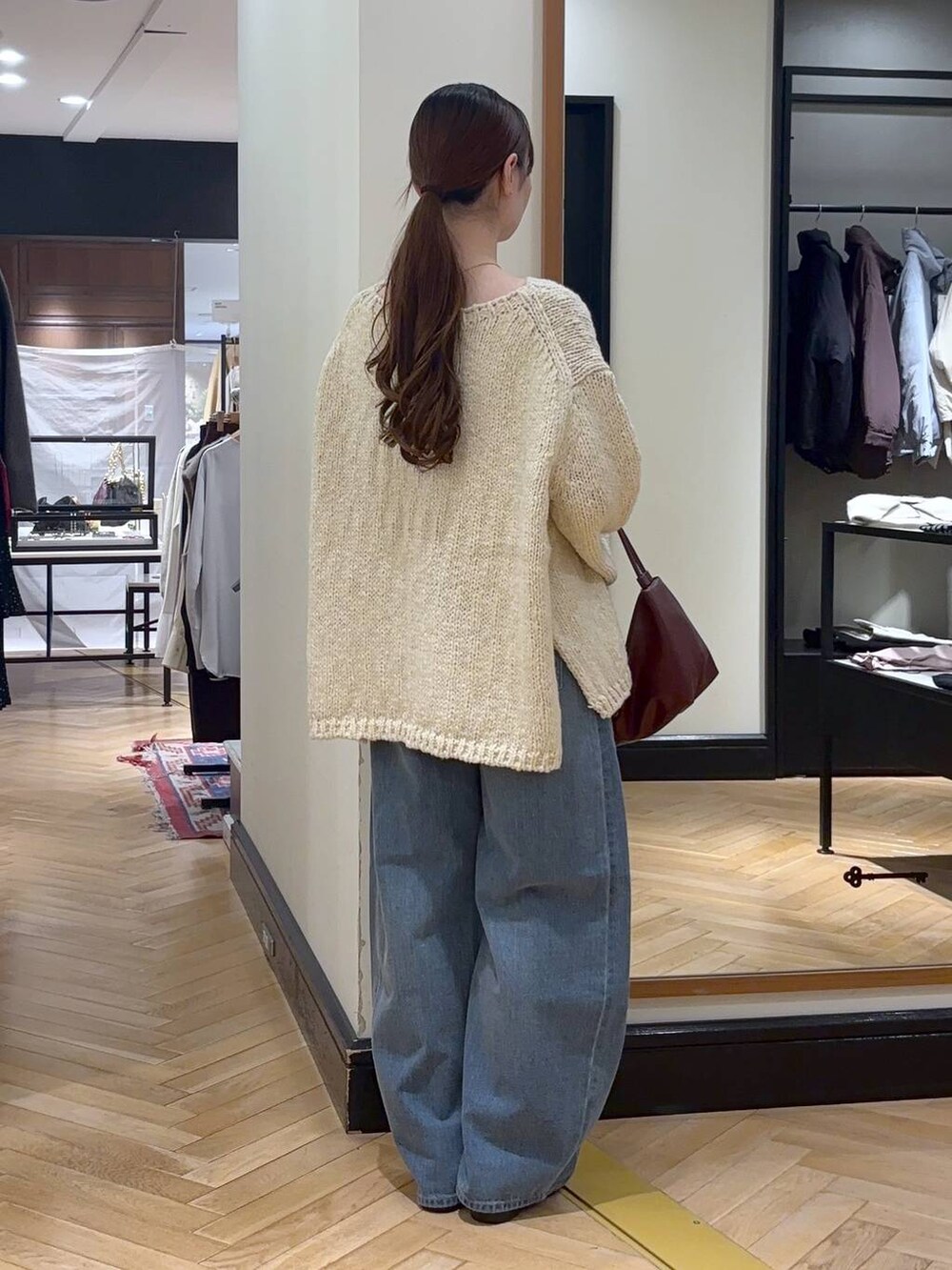 ブルー系のデニムパンツ、ベージュ系のノーカラーコート、ブラック系のショルダーバッグを着用したレディースの秋コーディネートの7枚目の写真