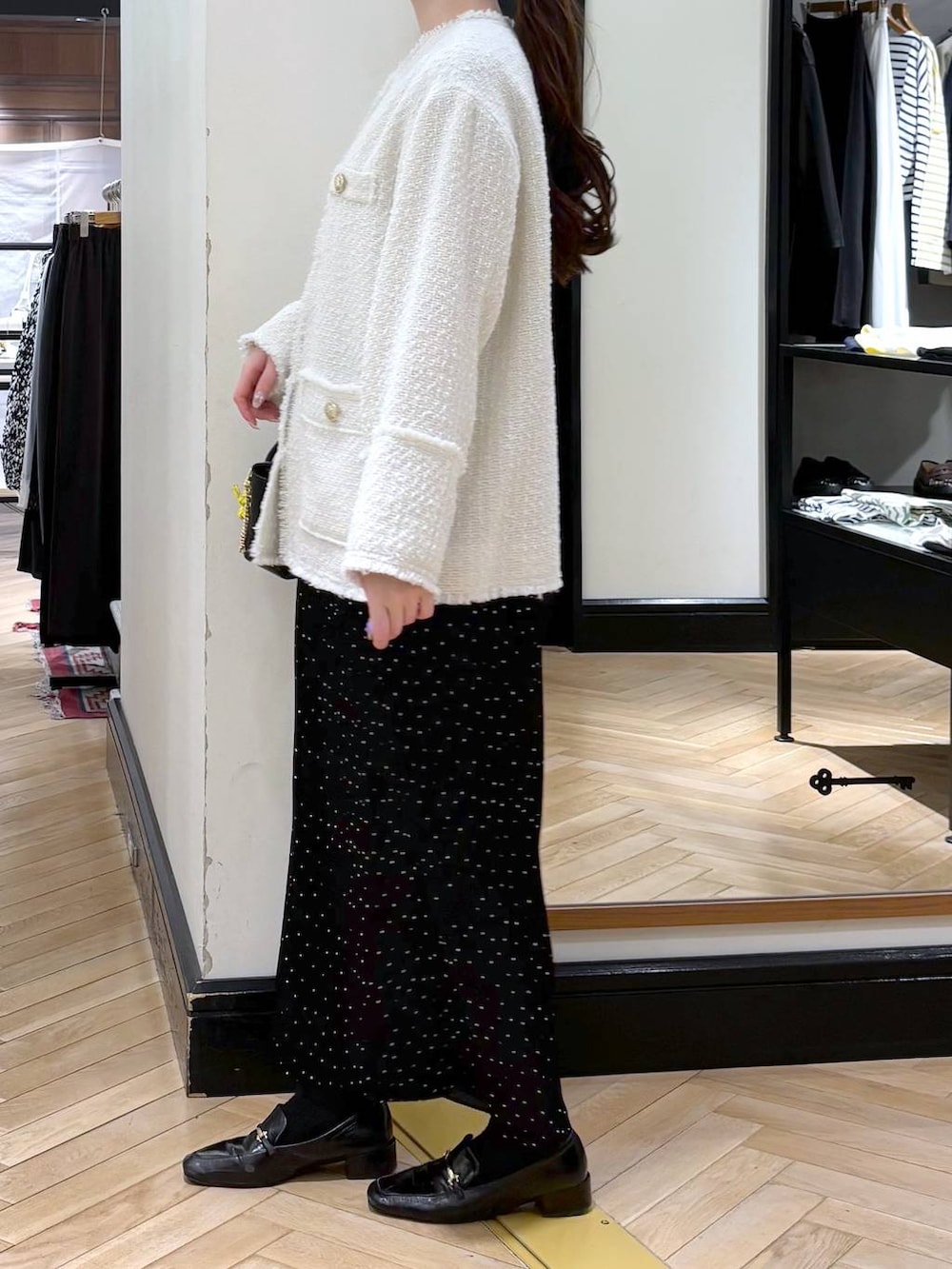 ブラック系のローファー、その他のスカート、ホワイト系のノーカラージャケットを着用したレディースの冬コーディネートの4枚目の写真