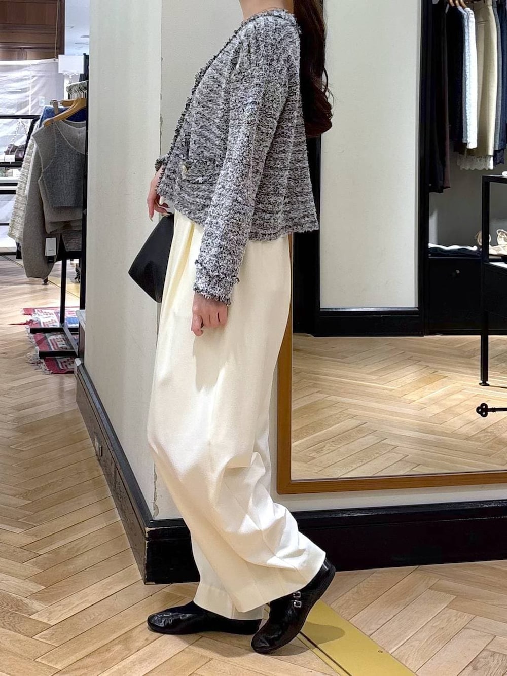 ホワイト系のスラックス、ブラック系のショルダーバッグ、ブラック系のカーディガン/ボレロを着用したレディースの冬コーディネートの5枚目の写真