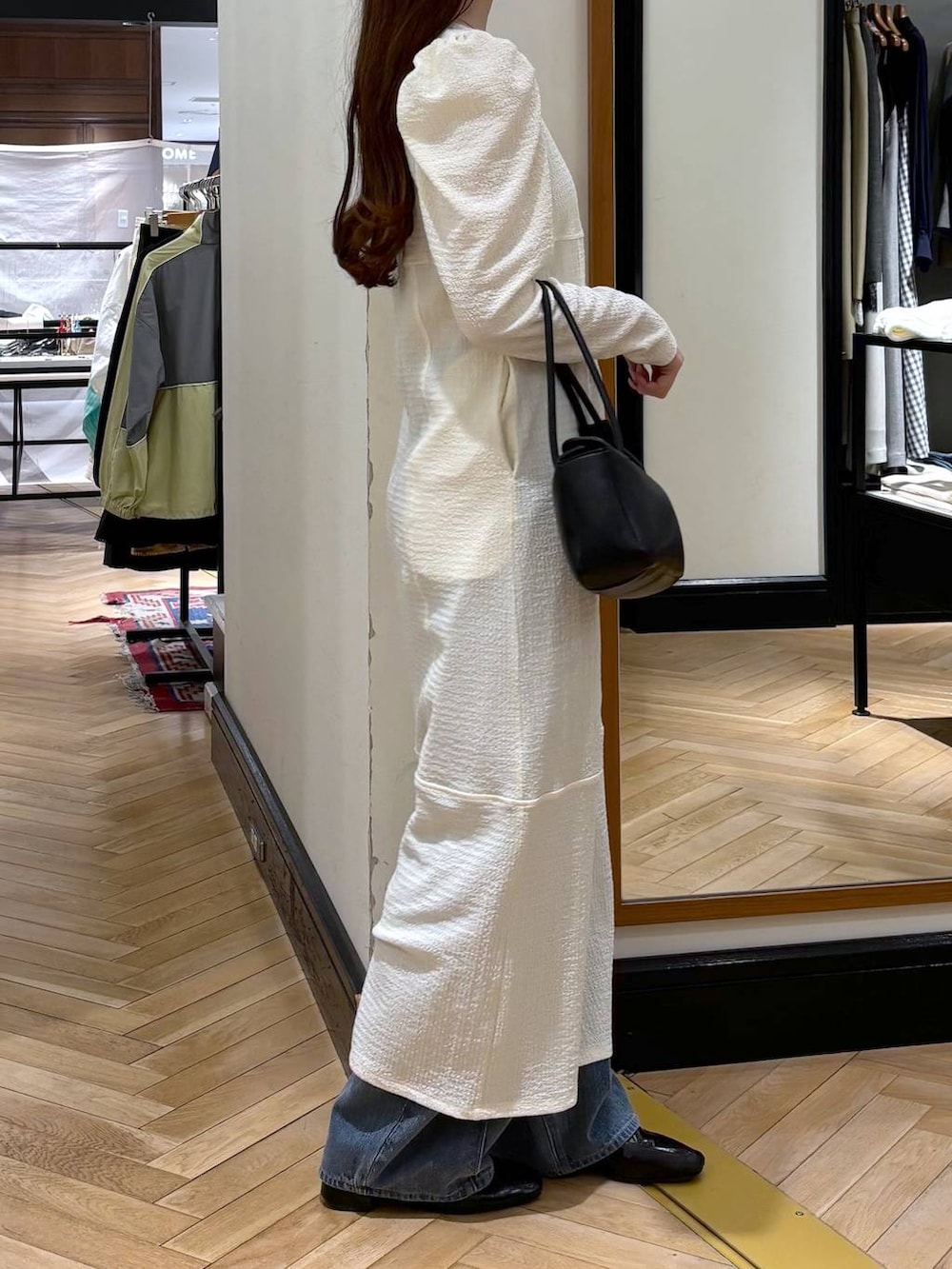 ブルー系のデニムパンツ、ブラック系のローファー、ブラック系のショルダーバッグを着用したレディースの春コーディネートの2枚目の写真