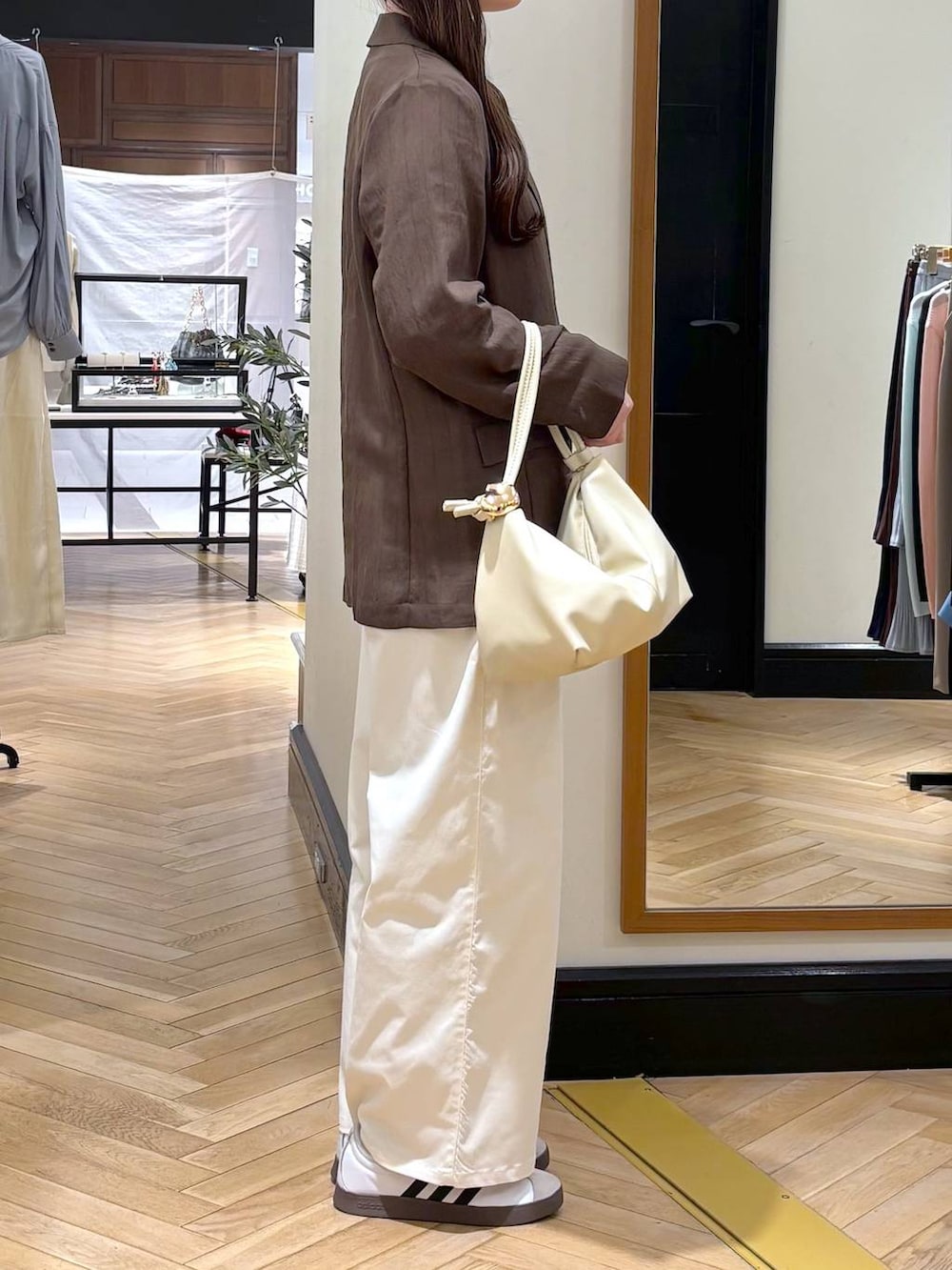 ブラウン系のテーラードジャケット、ベージュ系のショルダーバッグ、ホワイト系のTシャツ/カットソーを着用したレディースの春コーディネートの2枚目の写真
