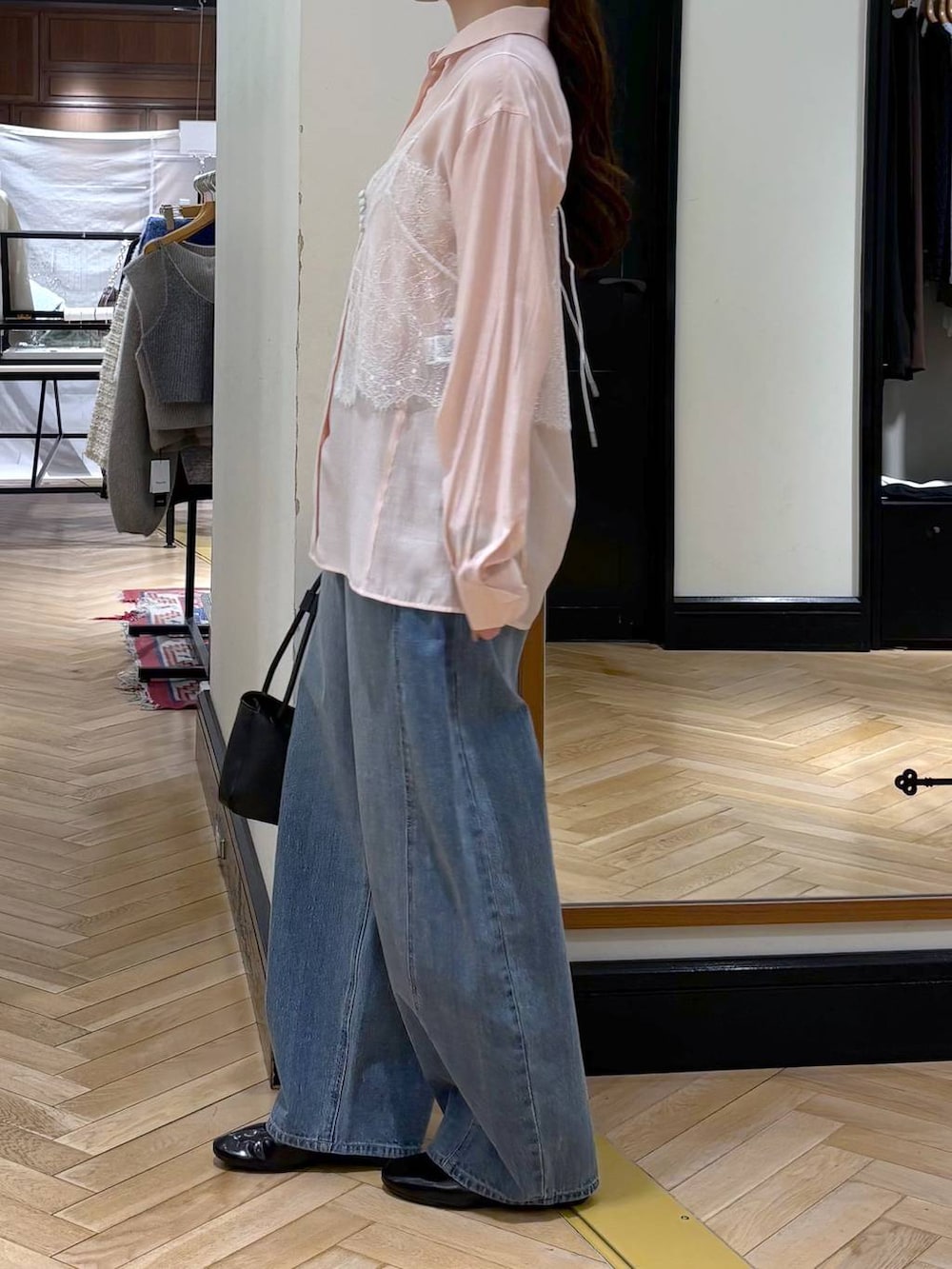 ブルー系のデニムパンツ、ブラック系のショルダーバッグ、ピンク系のシャツ/ブラウスを着用したレディースの冬コーディネートの4枚目の写真