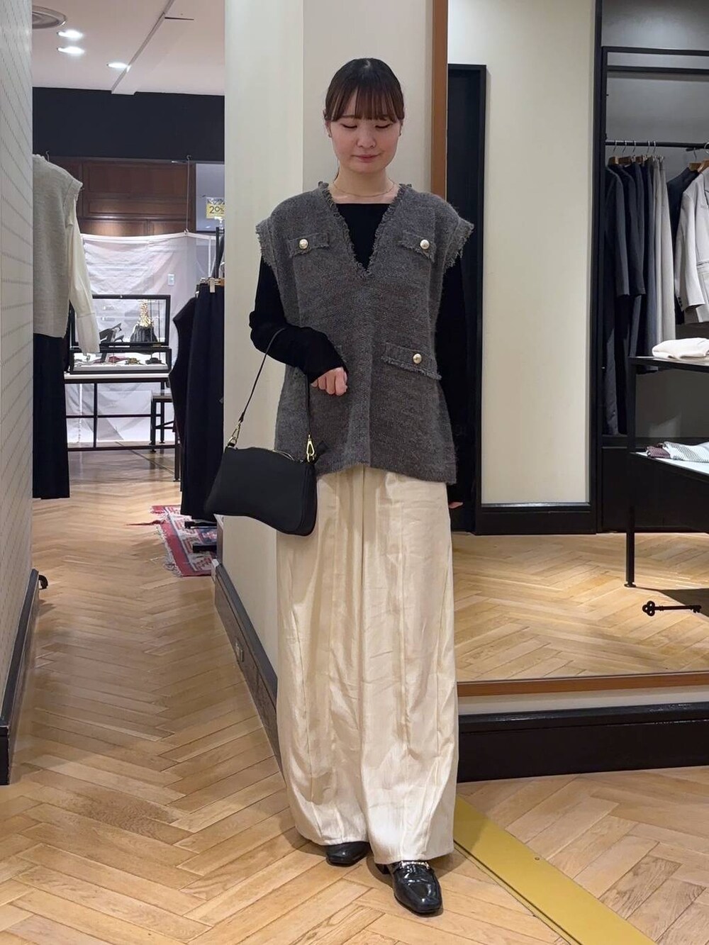 グレー系のベスト、ブラック系のローファー、ブラック系のTシャツ/カットソーを着用したレディースの秋コーディネートの2枚目の写真