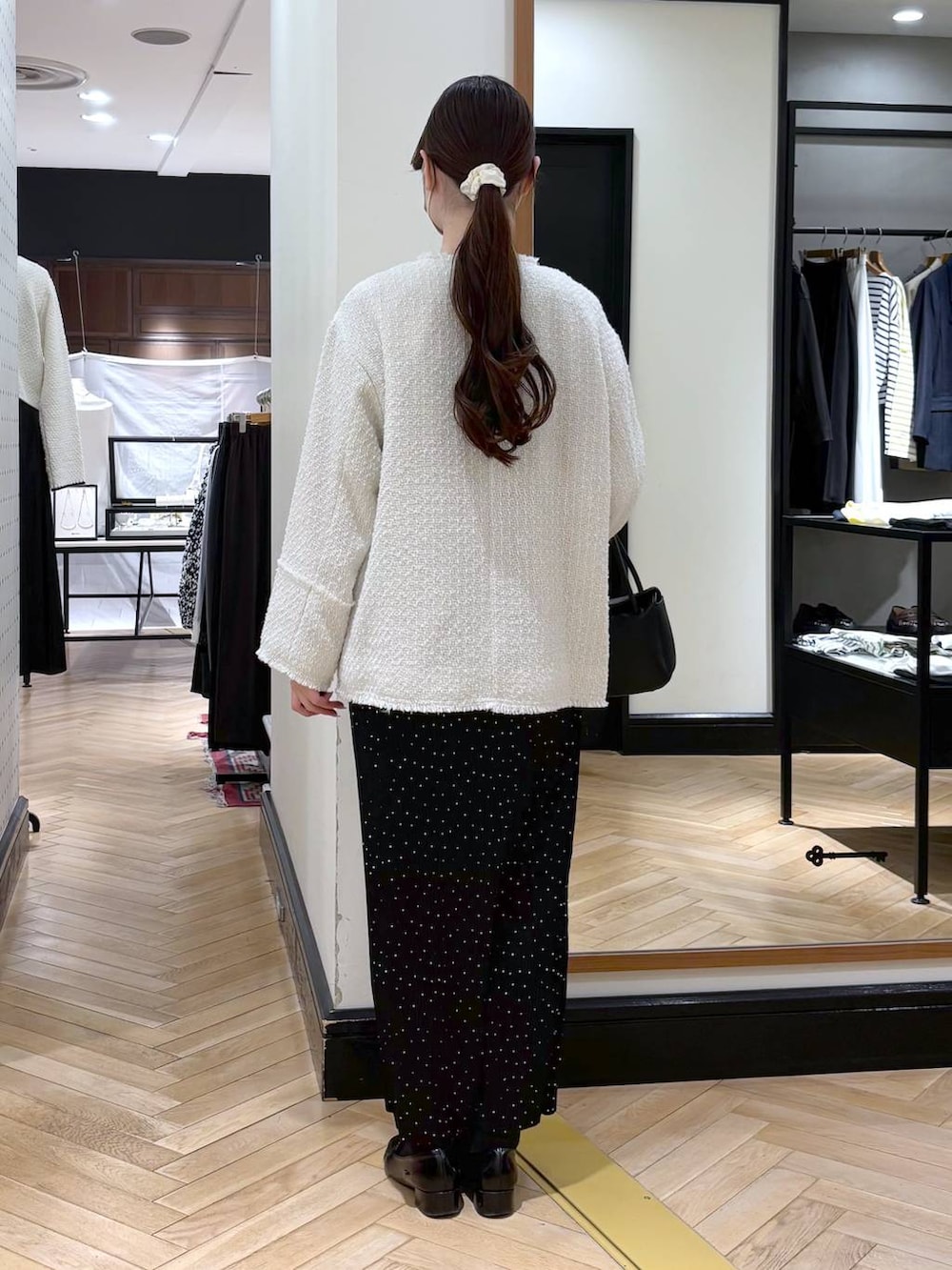 ブラック系のローファー、その他のスカート、ホワイト系のノーカラージャケットを着用したレディースの冬コーディネートの5枚目の写真