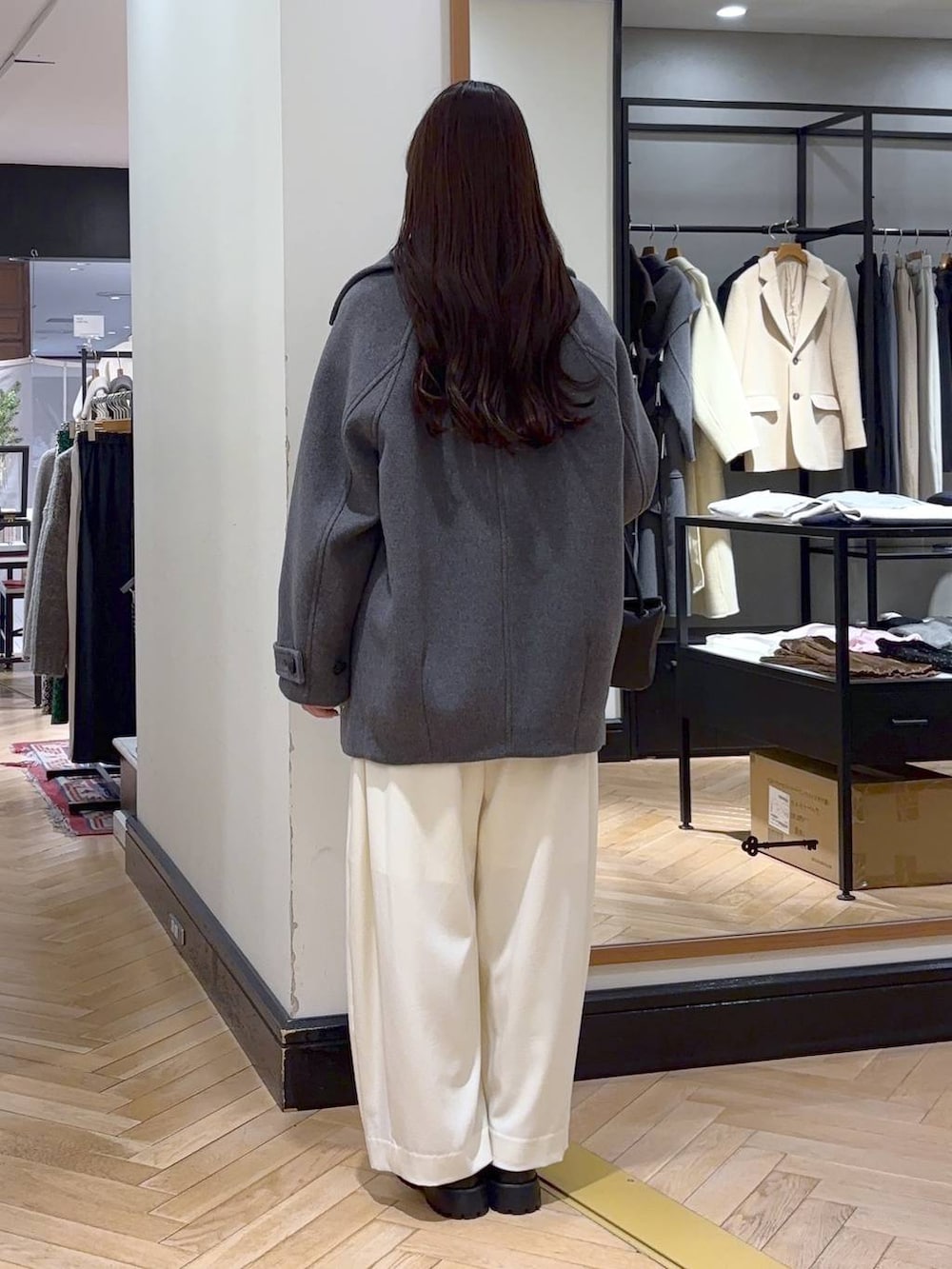 グレー系のピーコート、ホワイト系のスラックス、ブラック系のローファーを着用したレディースの冬コーディネートの4枚目の写真