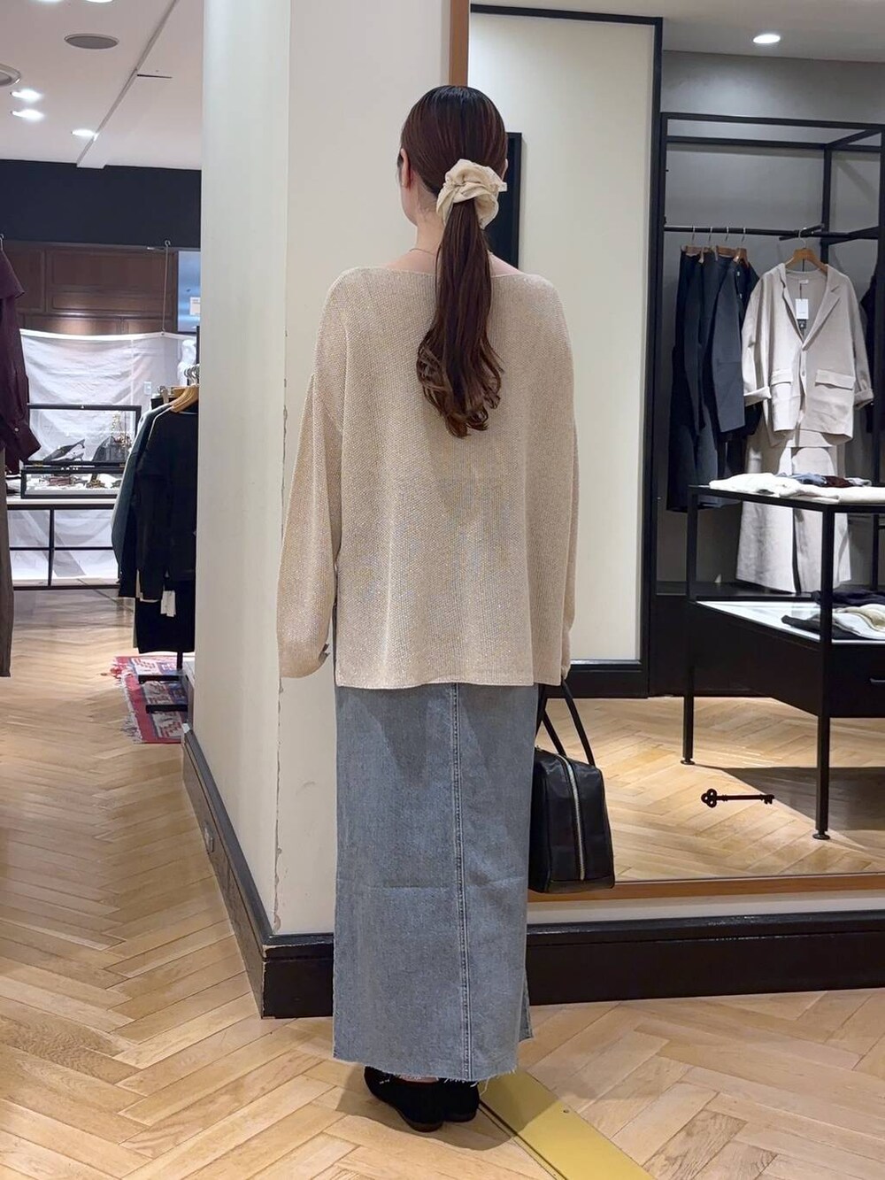 ブラック系のボストンバッグ、ブルー系のデニムスカート、ブラック系のバレエシューズを着用したレディースの秋コーディネートの5枚目の写真