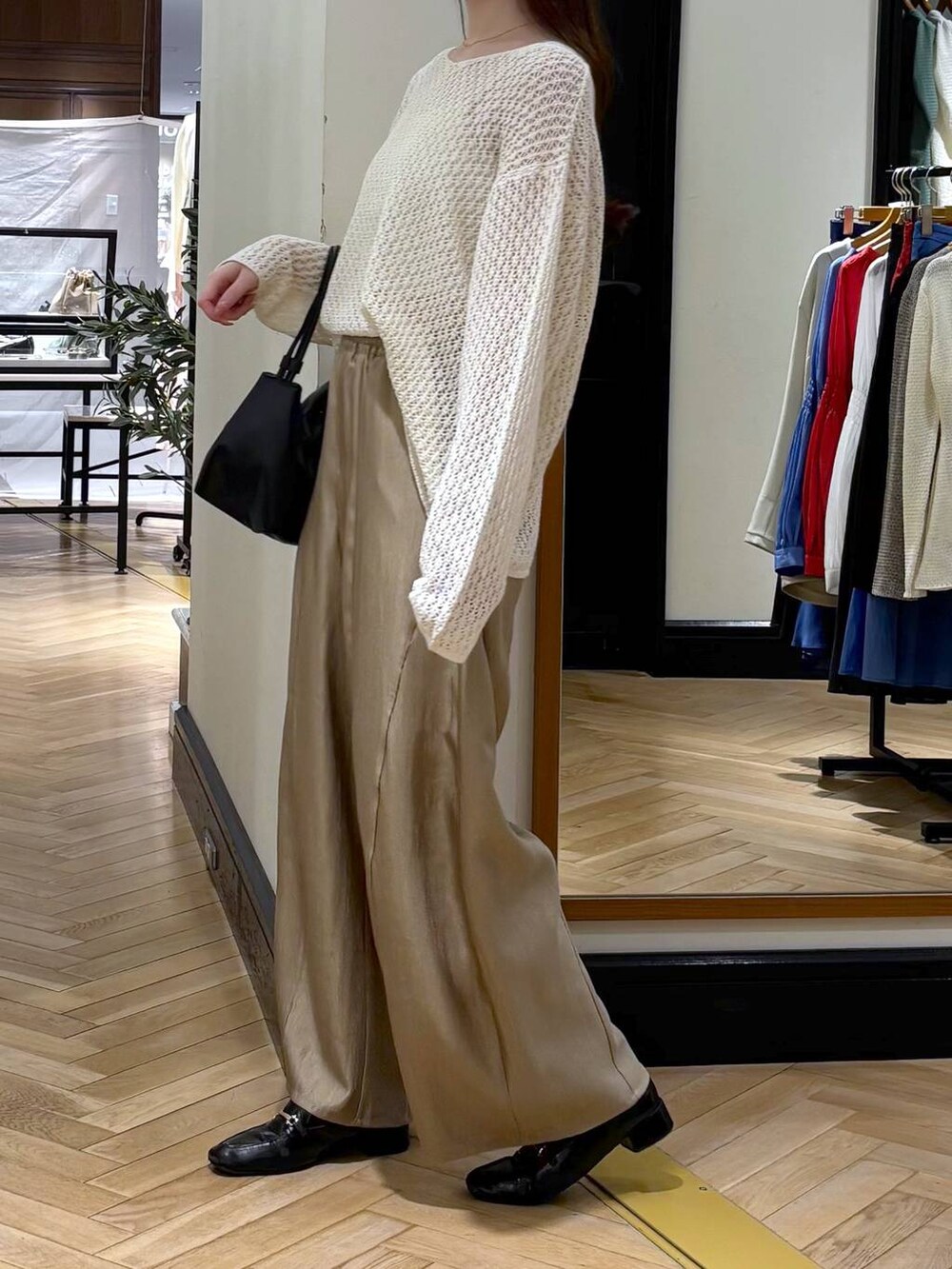 ブラック系のローファー、ベージュ系のその他パンツ、ブラック系のショルダーバッグを着用したレディースの春コーディネートの3枚目の写真