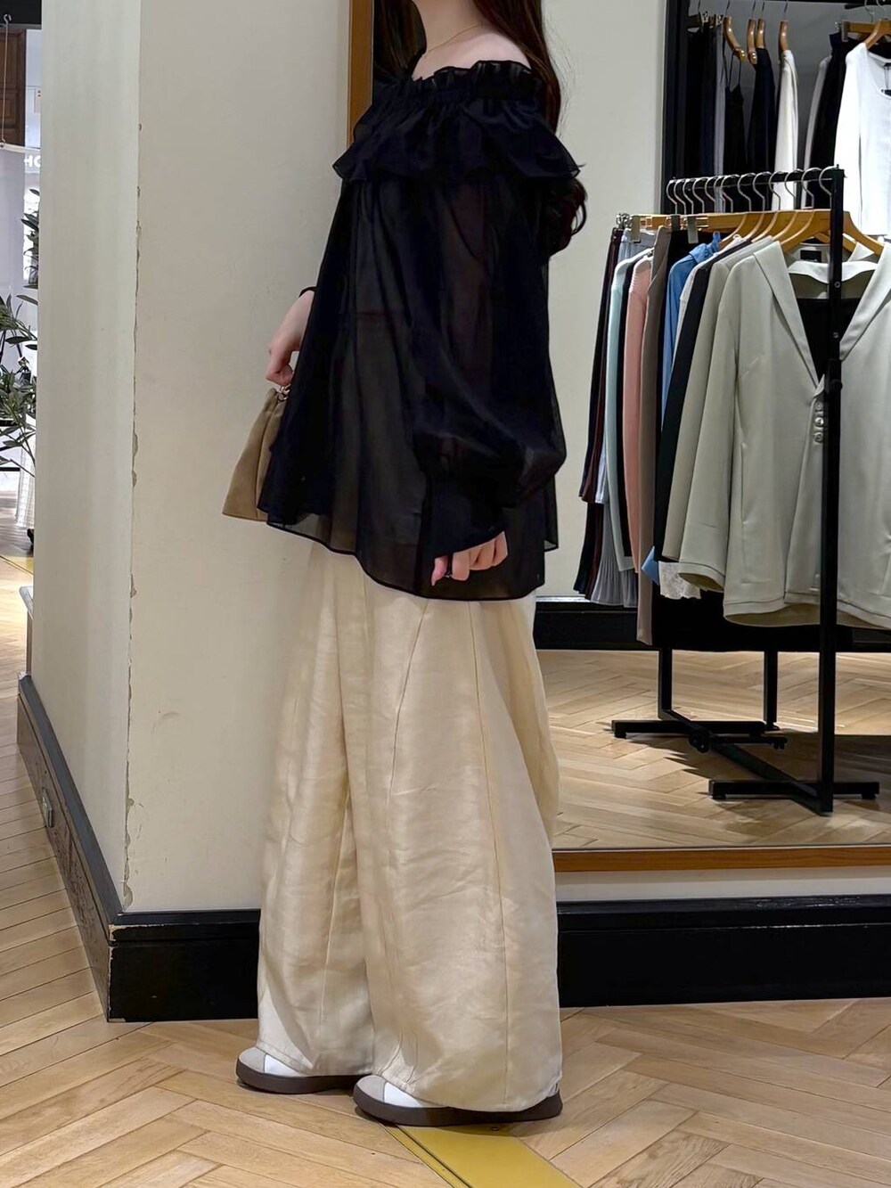 ホワイト系のその他パンツ、ベージュ系のショルダーバッグ、ブラック系のシャツ/ブラウスを着用したレディースの春コーディネートの3枚目の写真