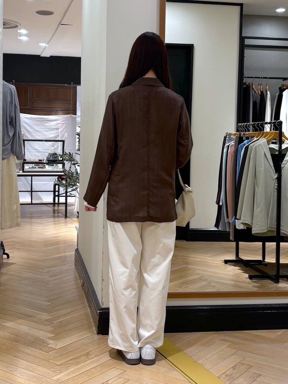 ブラウン系のテーラードジャケット、ベージュ系のショルダーバッグ、ホワイト系のTシャツ/カットソーを着用したレディースの春コーディネートの4枚目の写真