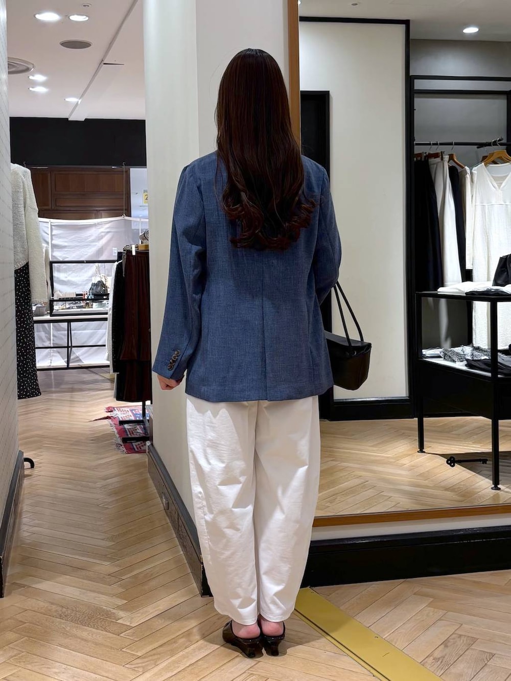 ブルー系のノーカラージャケット、ブラック系のショルダーバッグ、ブラック系のサンダルを着用したレディースの春コーディネートの4枚目の写真