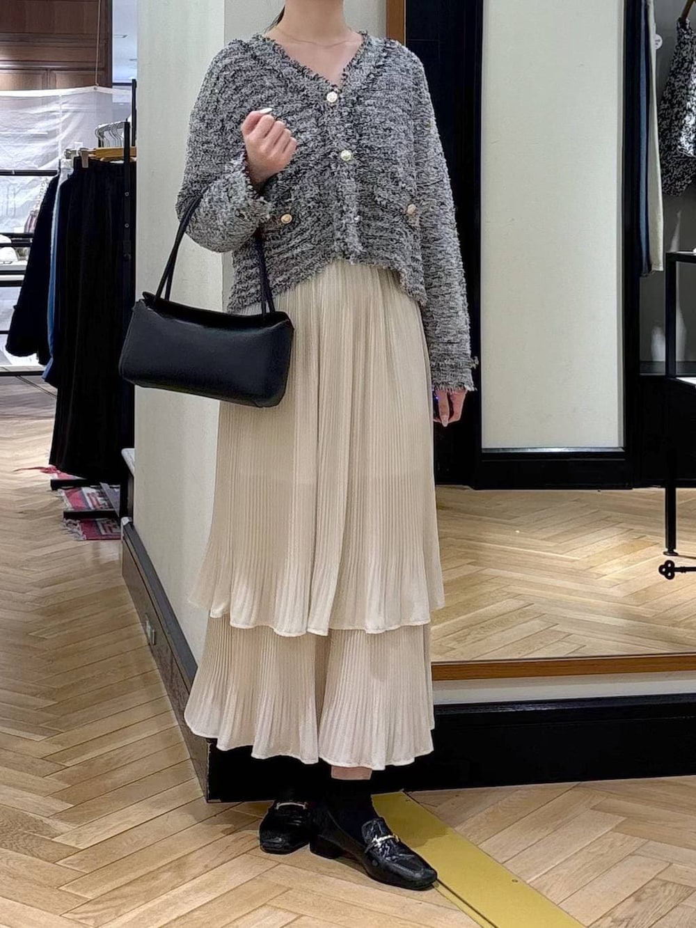 ホワイト系のスカート、ブラック系のローファー、ブラック系のカーディガン/ボレロを着用したレディースの冬コーディネートの2枚目の写真