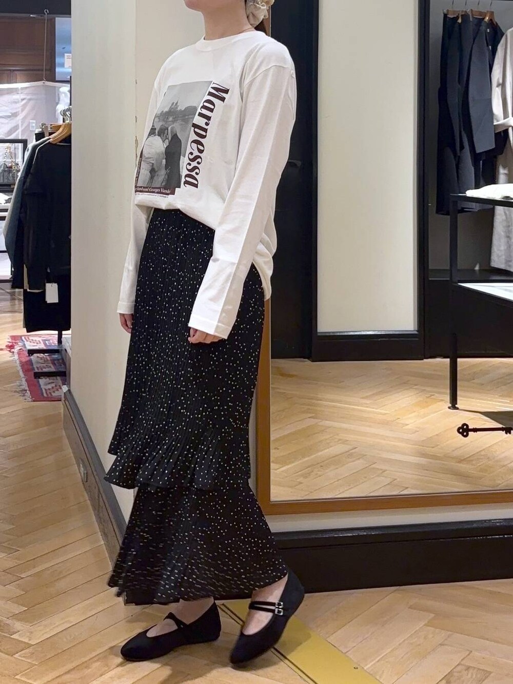 グレー系のスカート、ブラック系のバレエシューズ、ホワイト系のTシャツ/カットソーを着用したレディースの秋コーディネートの3枚目の写真