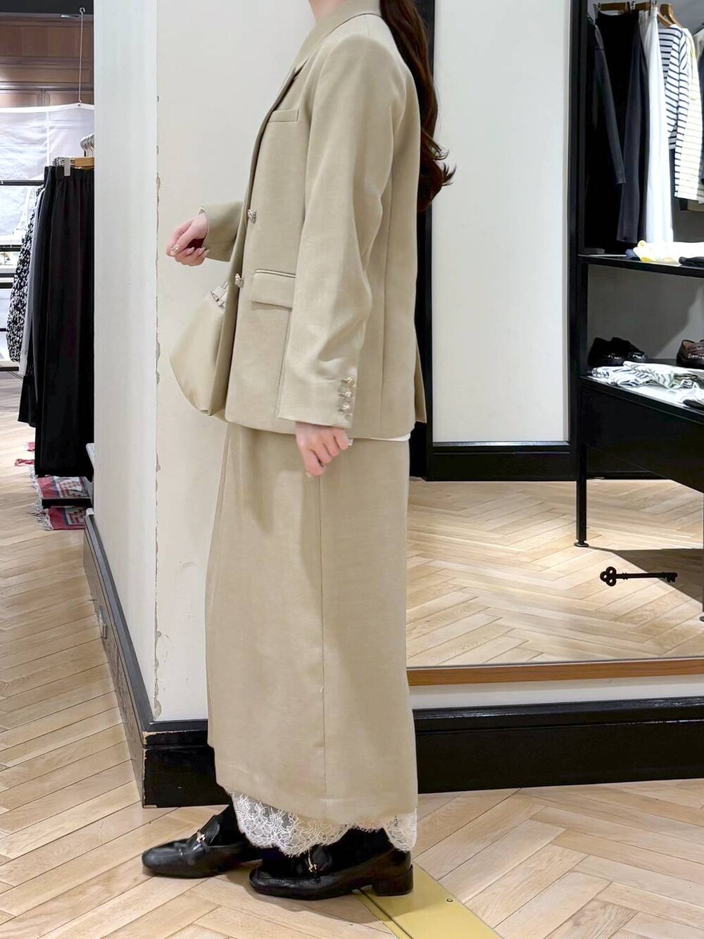 ブラック系のローファー、ベージュ系のスカート、ベージュ系のテーラードジャケットを着用したレディースの冬コーディネートの3枚目の写真